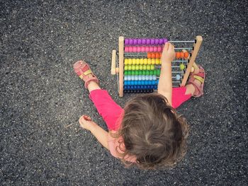 Directly above shot of young girl using colorful abacus