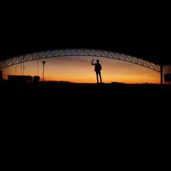 Silhouette people standing against sky at sunset