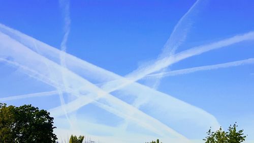 Low angle view of vapor trail against blue sky