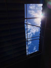 Low angle view of sunlight streaming through window on building