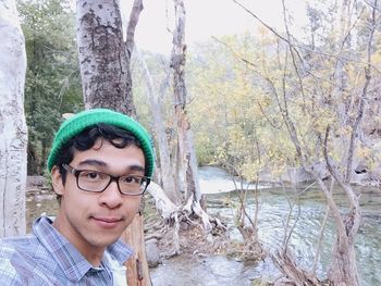 Portrait of man in river against trees in forest