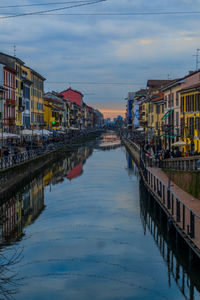 Canal amidst buildings in city against sky