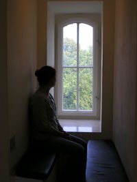 Man sitting in window at home