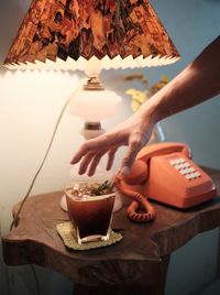 Midsection of woman holding drink on table