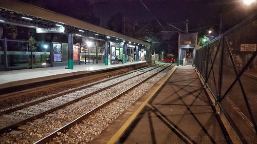 Illuminated railroad station platform at night