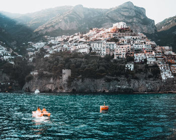 Scenic view of sea by city buildings