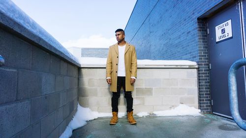 Full length portrait of man standing in city in winter