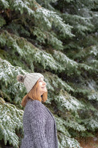 Woman wearing hat standing in forest