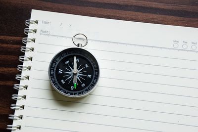 Close-up of navigational compass on notebook