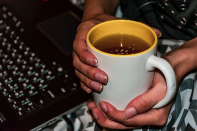 Midsection of woman holding coffee cup