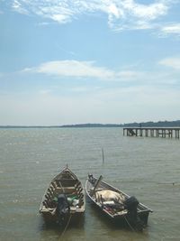 Boats moored on sea against sky