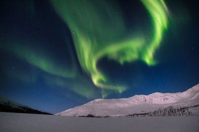 Scenic view of snowcapped mountains against sky at night