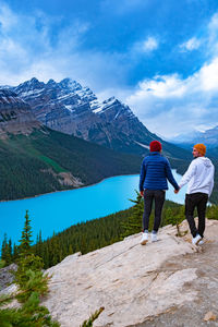 Rear view of people on mountain against sky