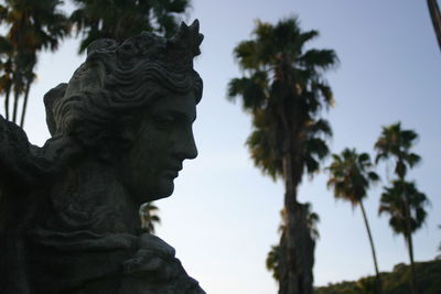 Low angle view of statue of palm trees against sky