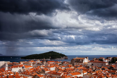 Town by sea against sky