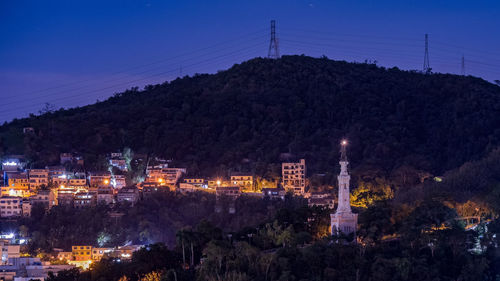 Illuminated buildings against sky at night