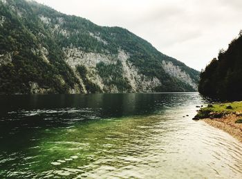 Scenic view of lake by mountains against sky