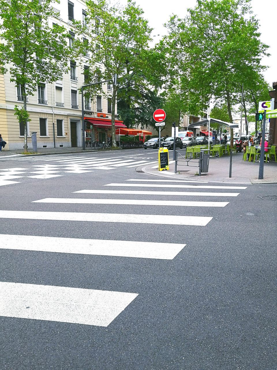 road, road marking, street, transportation, road sign, guidance, tree, city, communication, zebra crossing, asphalt, day, car, the way forward, red, outdoors, arrow symbol, incidental people, sign, directional sign