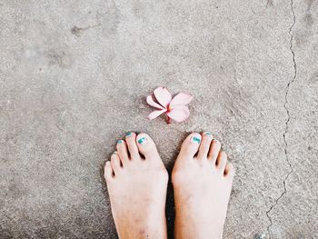 Low section of woman standing on flower