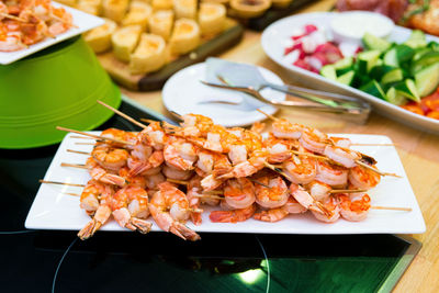 Shrimp kebabs on skewers on the festive table appetizer set on the catering table