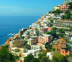 High angle view of houses by sea against clear sky