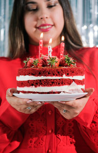 Midsection of woman holding cake