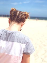 Rear view of girl standing at beach