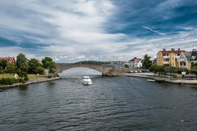 Buildings by river against sky