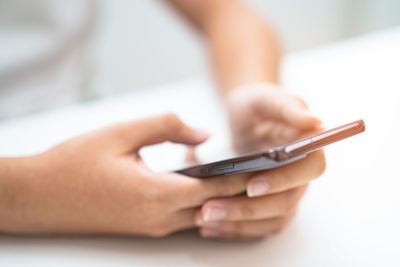 Cropped hands of woman using mobile phone