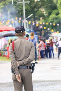 Rear view of security guard standing in city