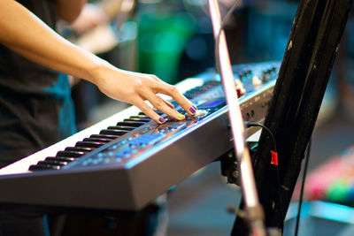 Close-up of hand playing piano