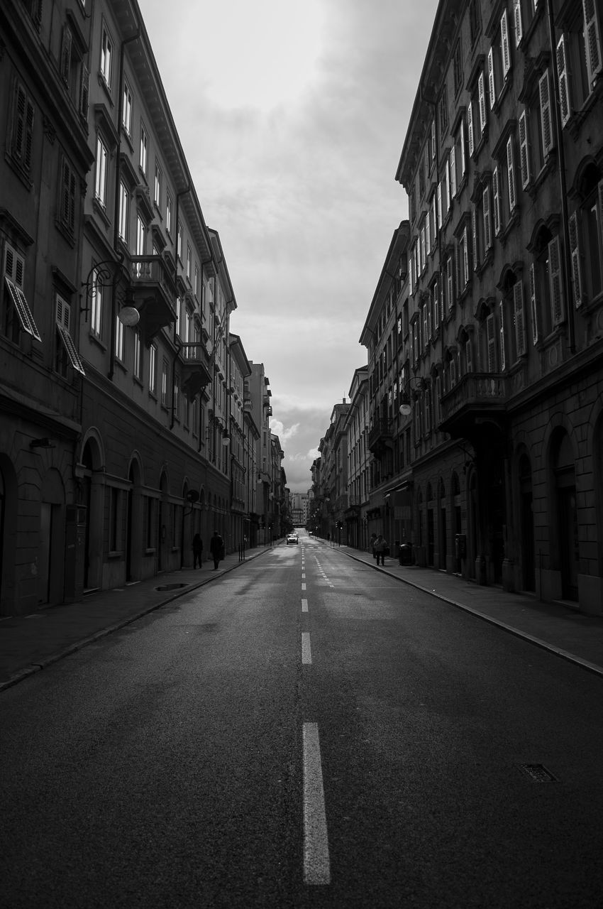 ROAD AMIDST BUILDINGS AGAINST SKY