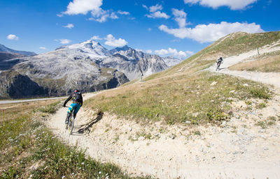 Downhill mountain biker in front of the grande motte glacier in summer in the vanoise massif