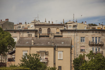 Buildings in city against cloudy sky