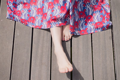 Low section of woman standing on wooden floor