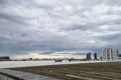 Road by buildings against sky in city