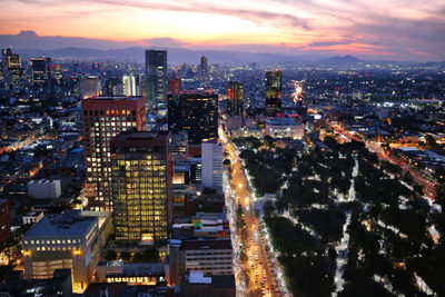 High angle view of illuminated city buildings against sky