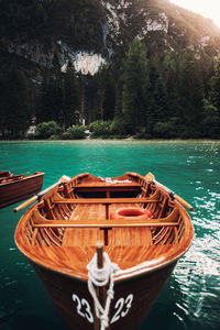 Boat moored on river by tree mountain