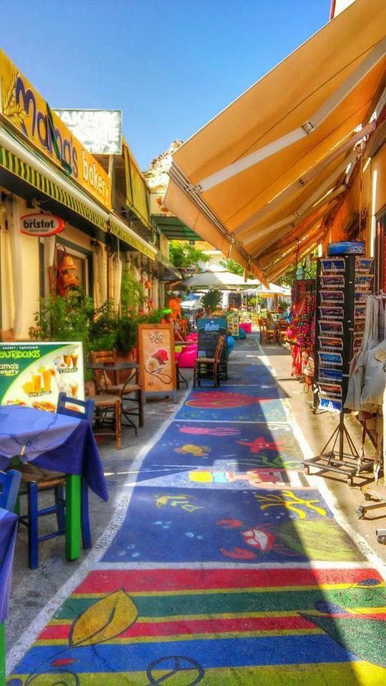 architecture, built structure, building exterior, empty, blue, multi colored, clear sky, sunlight, in a row, absence, chair, city, sky, incidental people, day, outdoors, table, restaurant, shadow, no people