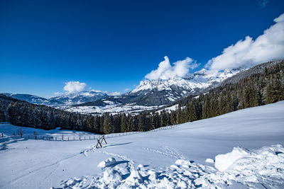 Scenic view of snowcapped mountains against blue sky