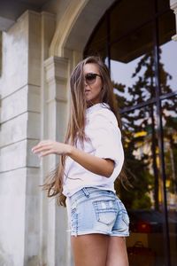 Full length of woman standing against wall