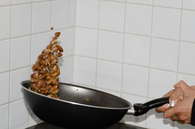 Cropped hands of man preparing food in kitchen