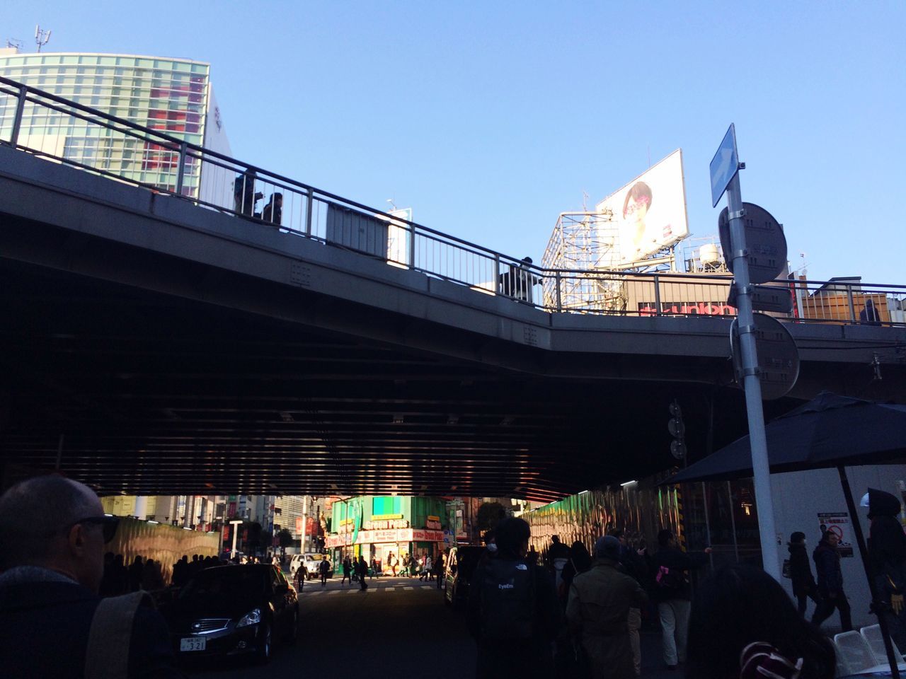 architecture, built structure, building exterior, large group of people, clear sky, men, person, lifestyles, city, transportation, city life, leisure activity, walking, medium group of people, sunlight, street, travel, mixed age range, day