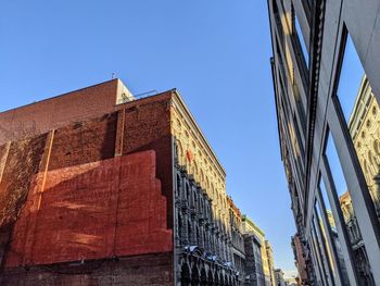 Low angle view of buildings against clear blue sky