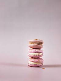 French or italian macarons with coffee and vanilla filling on pink background. 