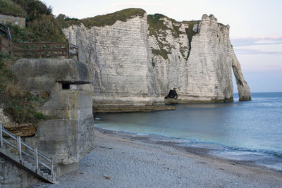 Rock formations on beach against sky