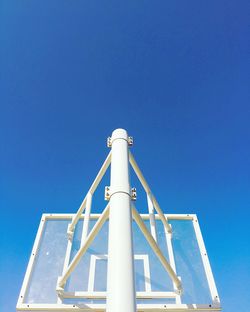 Low angle view of crane against clear blue sky