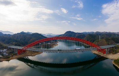 Arch bridge over river against sky