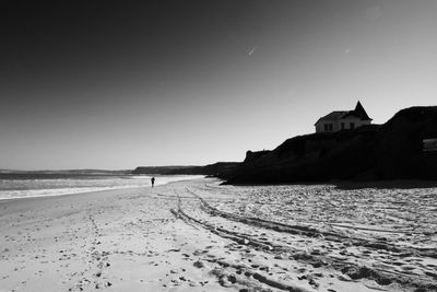 Scenic view of beach by sea against clear sky