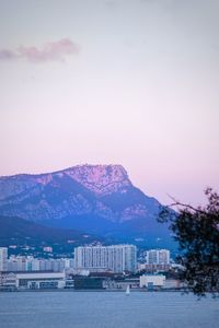 City by sea against sky during sunset